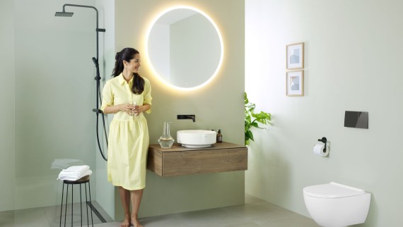 Kobieta w łazience z lustrem Geberit Option i umywalką Geberit VariForm
