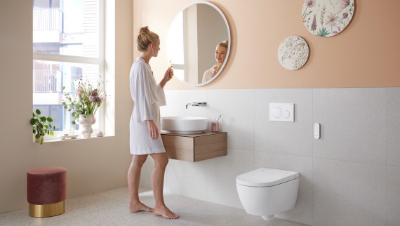 Kobieta w łazience z Geberit AquaClean Alba - ekonomiczną toaletą z funkcją bidetu i natrysku
