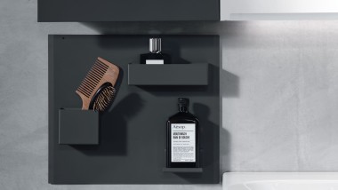 Tablica magnetyczna Geberit w łazience, w której umieszczone są: szczotki do włosów i butelki Tablica magnetyczna Geberit w łazience, w której umieszczone są: szczotki do włosów i butelki