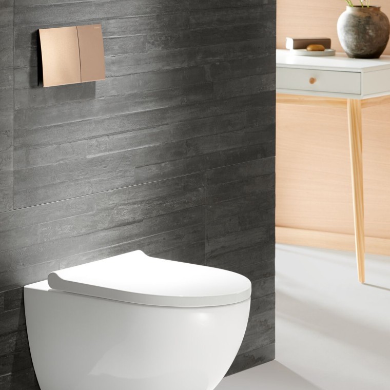 ALT: Miska WC Geberit Acanto z przyciskiem spłukującym Sigma70 w kolorze różowego złota ALT: Miska WC Geberit Acanto z przyciskiem spłukującym Sigma70 w kolorze różowego złota