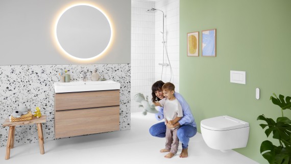 Kobieta z dzieckiem w łazience. Na pierwszym planie toaleta myjąca Geberit AquaClean Alba