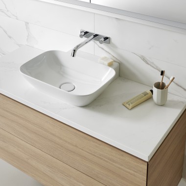 Umywalka z białymi ceramicznymi urządzeniami i drewnianymi meblami łazienkowymi (© Geberit)