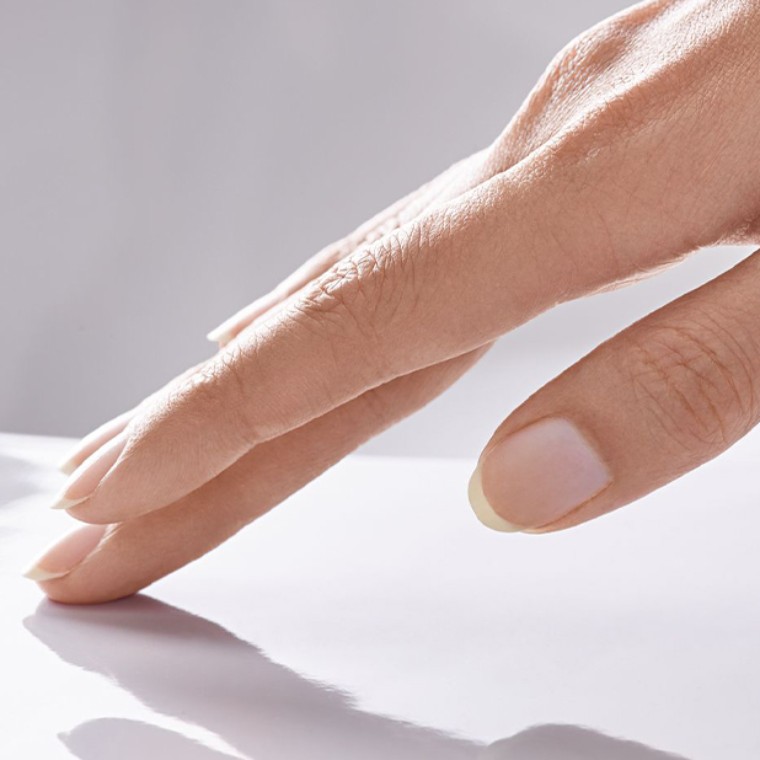 Kobieca dłoń dotyka powierzchnię umywalki wykończoną szkliwem KeraTect Kobieca dłoń dotyka powierzchnię umywalki wykończoną szkliwem KeraTect