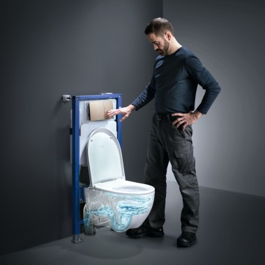 Mężczyzna uruchamia technologię spłukiwania TurboFlush toalety Geberit Acanto