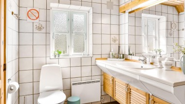 Oryginalna łazienka z podłogową toaletą, białymi płytkami i drewnianymi meblami łazienkowymi (© @triner2 i @strandparken3)
