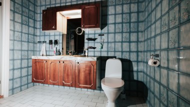 Łazienka z niebieskimi kafelkami i WC na podłodze