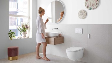 Kobieta w białej łazience z ceramiką i meblami łazienkowymi Geberit