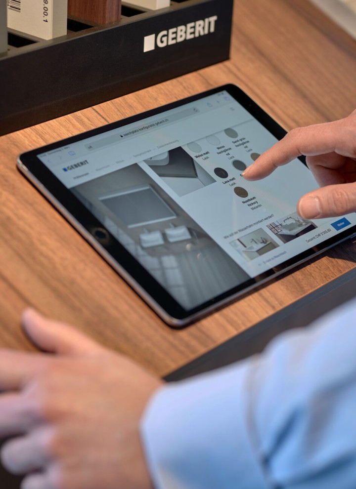 Czołowiek wybierający produkty w konfiguratorze na ekranie tabletu.