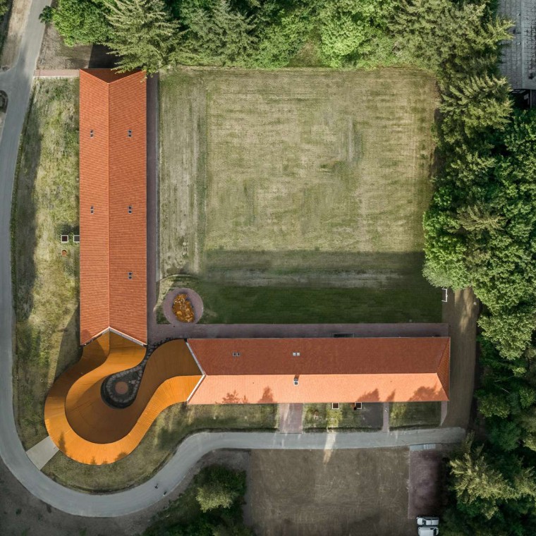 Widok z góry pokazuje okrągły nowy budynek, który łączy dwa zabytkowe budynki pokryty dachówką (© R_Hjortshoj) Widok z góry pokazuje okrągły nowy budynek, który łączy dwa zabytkowe budynki pokryty dachówką (© R_Hjortshoj)