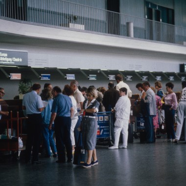 Pasażerowie oczekujący w strefie tranzytowej Terminalu A (zdjęcie z 1986 r.). (© ETH-Bibliothek Zürich) Pasażerowie oczekujący w strefie tranzytowej Terminalu A (zdjęcie z 1986 r.). (© ETH-Bibliothek Zürich)