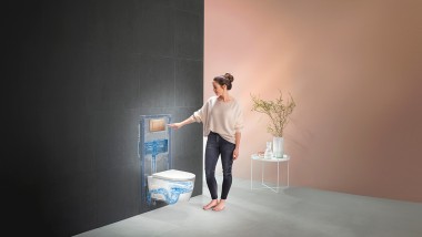 Kobieta uruchamiająca spłukiwanie Geberit WC System (© Geberit)