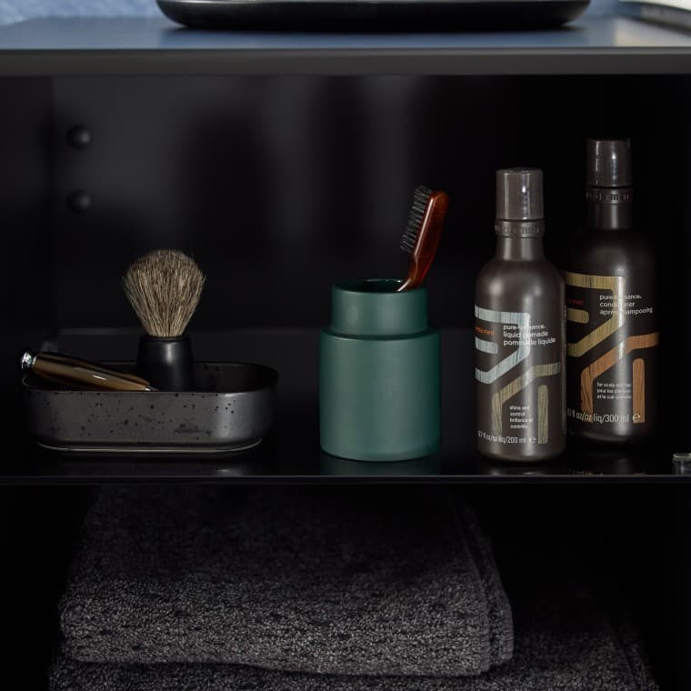 Czarna półka łazienkowa, na której znajdują się kosmetyki i przybory kosmetyczne Czarna półka łazienkowa, na której znajdują się kosmetyki i przybory kosmetyczne