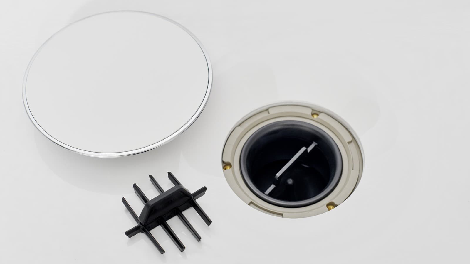 Pokrywa odpływu brodzikowego Geberit i wkład grzebieniowy leżą obok odpływu Pokrywa odpływu brodzikowego Geberit i wkład grzebieniowy leżą obok odpływu