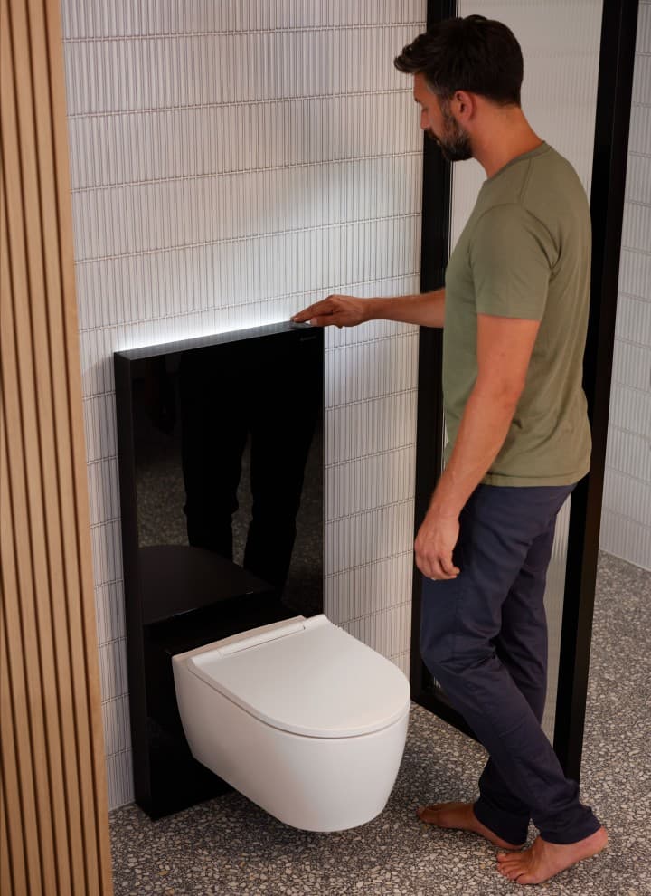 Mężczyzna obok Geberit Monolith Plus z ComfortLight Mężczyzna obok Geberit Monolith Plus z ComfortLight