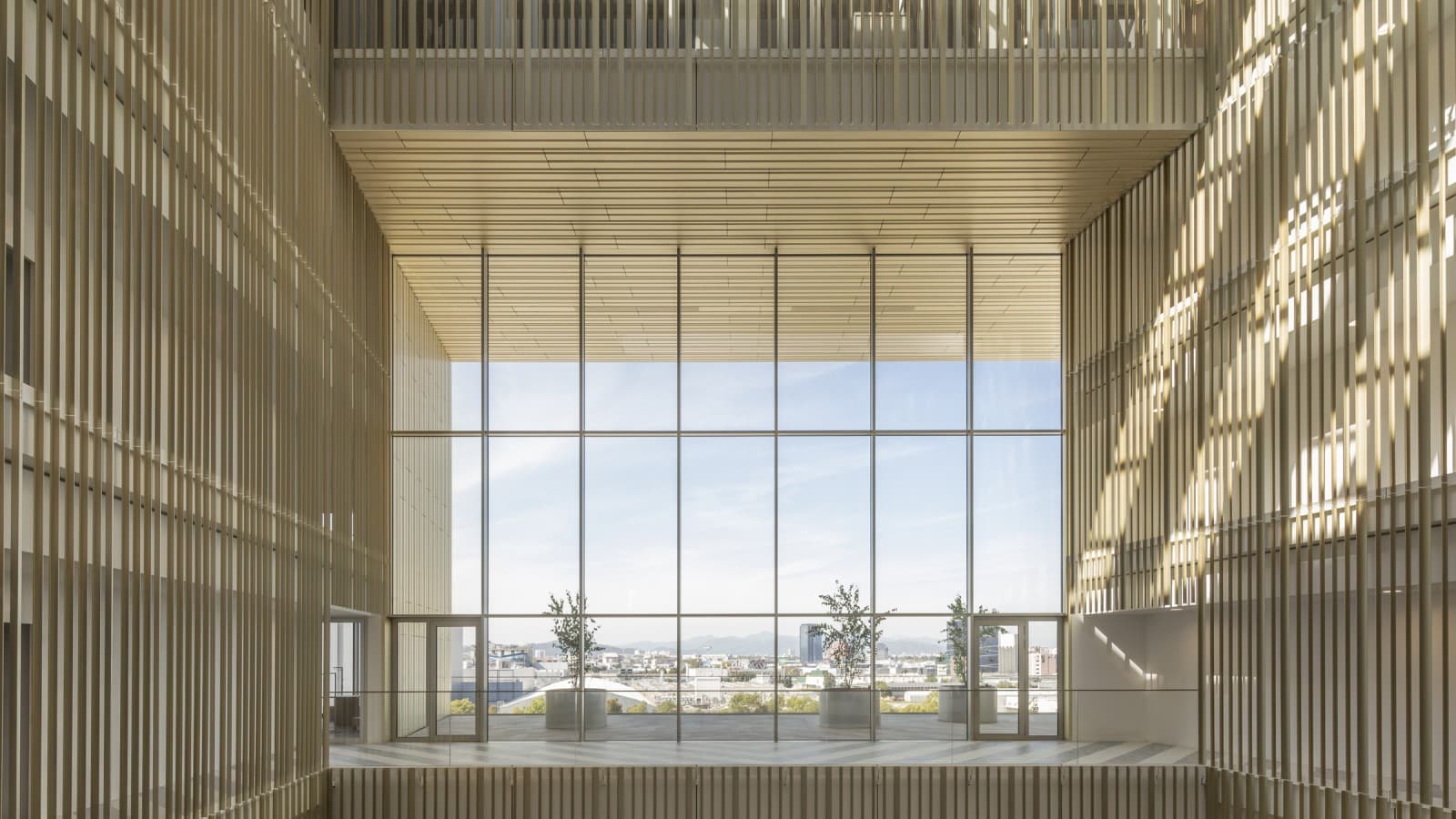 Atrium pokryte jest profilami z anodowanego aluminium pokrytego złotem, których odcienie zmieniają się w zależności od kąta padania promieni słonecznych. (© Ana Skobe) Atrium pokryte jest profilami z anodowanego aluminium pokrytego złotem, których odcienie zmieniają się w zależności od kąta padania promieni słonecznych. (© Ana Skobe)